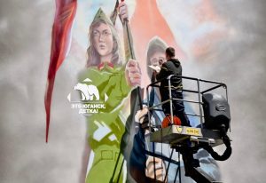 Художник из Нефтеюганска Александр Сажин нарисовал легендарную бабушку Анну с флагом СССР на стене школы №47 в Донецке.